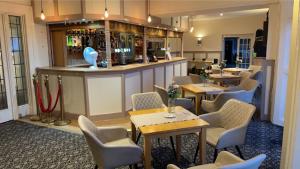 a restaurant with tables and chairs and a bar at Royal Grosvenor Hotel in Weston-super-Mare