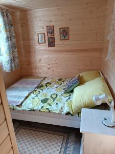 a small room with a bed in a log cabin at Między Lasem a Wodą in Nowe Worowo