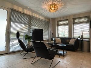 ein Wohnzimmer mit einem Sofa, einem Tisch und Stühlen in der Unterkunft Escape, appartement met groot terras in Buren