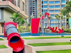 un parque infantil con equipo de juegos rojos en una ciudad en Bali Residence I Luxury 2BR I 6-10pax I Jonker St I Water Park I City Centre by Jay Stay, en Melaka