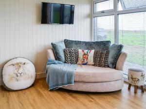 salon z kanapą z poduszkami w obiekcie The Seaview Snug w mieście Whithorn