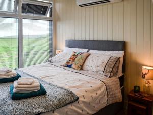 sypialnia z dużym łóżkiem i oknem w obiekcie The Seaview Snug w mieście Whithorn