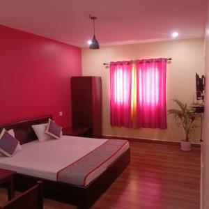 a bedroom with a bed and a red wall at Olive Residency 4BHK Villa with a Parking, Wifi, Campfire, Homemade Food in Kodaikānāl