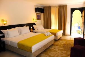 Habitación de hotel con 2 camas y ventana en Majorel Perle Hôtel Riad Restaurant Picine & Spa, en Marrakech