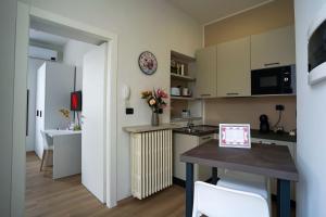 a small kitchen and dining room with a table and chairs at [Dalia Suite] Leonardo Academy, MXP & Lakes in Sesto Calende