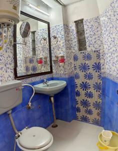 baño azul y blanco con aseo y lavamanos en Mcleodganj Bed & Breakfast, en McLeod Ganj
