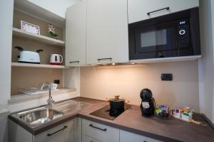 a kitchen with a sink and a microwave at [Dalia Suite] Leonardo Academy, MXP & Lakes in Sesto Calende