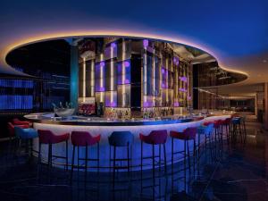 un bar en un edificio con taburetes rojos en Prince Hotel, Marco Polo, en Hong Kong