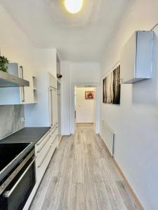 a kitchen with white cabinets and a wooden floor at Deluxe Studio 3P TH in Vienna