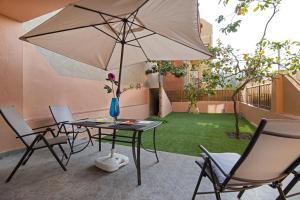 un patio con mesa, sillas y sombrilla en Holiday home Splendid Park Güell, en Barcelona