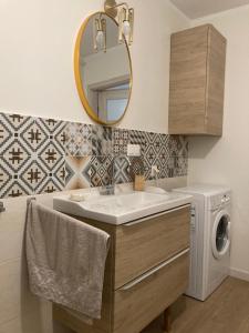 a bathroom with a sink and a washing machine at Uroczy Apartament u Mirki in Podgórzyn