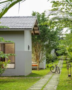 a bike parked next to a white house at Coffee Greens Resort in Wayanad