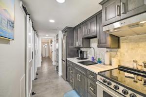 a kitchen with gray cabinets and a sink and a counter at Oceanfront Resort Condo in North Myrtle Beach in Myrtle Beach