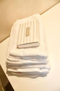 ein Stapel weißer Handtücher auf einem Regal in der Unterkunft La Casetta del Marinaio in Fano + 25 Fotos