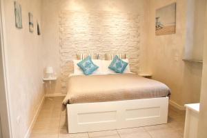 ein kleines Schlafzimmer mit einem Bett mit blauen Kissen in der Unterkunft La Casetta del Marinaio in Fano