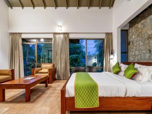 a bedroom with a bed and a living room at Coffee Greens Resort in Wayanad