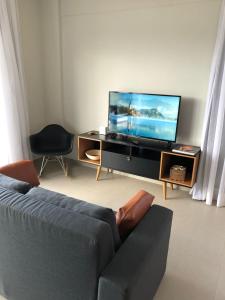 a living room with a couch and a flat screen tv at Recanto dos Ipês 1 in Domingos Martins