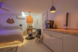 a bedroom with a bed and a kitchen with a counter at LES BAINS D’EROS in Cuers