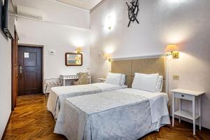 a hotel room with two beds and a table at Hotel Alessandra in Florence
