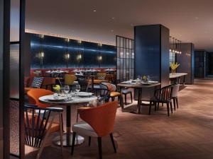 un restaurante con mesas y sillas y un bar en Prince Hotel, Marco Polo en Hong Kong