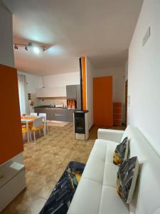 ein Wohnzimmer mit einem weißen Sofa und einer Küche in der Unterkunft Casa Linda in Cisternino