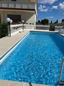 ein großer blauer Pool neben einem Haus in der Unterkunft Casa Linda in Cisternino