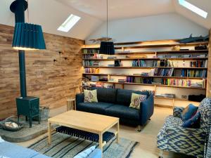 een woonkamer met een bank en een boekenplank bij Burmieston in Perth