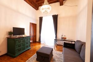- un salon avec un canapé et une télévision dans l'établissement Rome s Suite Bramante, à Rome