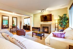 a living room with a white couch and a fireplace at Spacious Kent Home Near SeaTac Airport with Patio in Kent