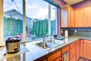 a kitchen with a sink and a large window at Spacious Kent Home Near SeaTac Airport with Patio in Kent