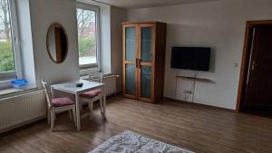 a living room with a table and a television at Jutta-vom-Kutter in Wulfen auf Fehmarn