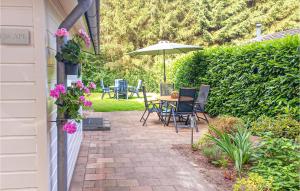 une terrasse avec une table, des chaises et un parasol dans l'établissement Stunning Home In Vorden With Wifi, à Vorden