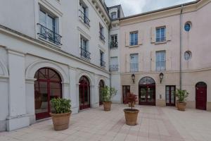 un patio con macetas frente a un edificio en Place Toscane Disney dream III BMYGUEST, en Serris