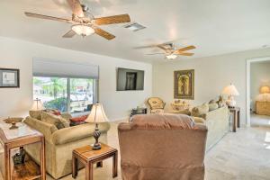 een woonkamer met twee banken en een plafondventilator bij 6 Mi to Dtwn Cape Coral Home with Spacious Lanai! in Cape Coral