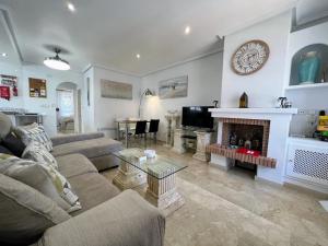 Una sala de estar con un sofá y una chimenea. en Nice Ground Floor Apartment with Communal Pool in Los Dolses LD279, en Orihuela