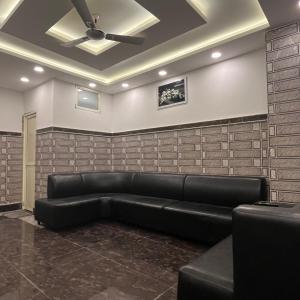 a black leather couch in a room with a ceiling at Hotel Shanti Residency in Katra