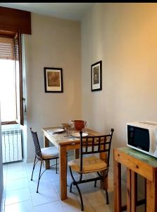 uma sala de jantar com uma mesa com cadeiras e uma televisão em bb26 Piave apartment city center em Cremona