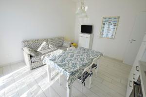 サン·ヴィンチェンツォにあるColombo apartment, fronte spiaggiaのテーブルとソファのあるリビングルーム