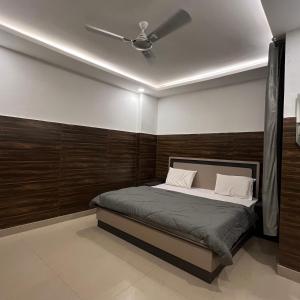 a bedroom with a bed with a ceiling fan at Hotel Shanti Residency in Katra