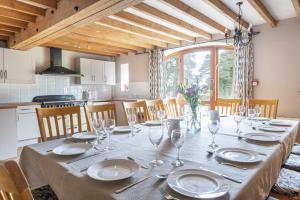 a dining room table with plates and glasses on it at Somersal Cottages in Ashbourne
