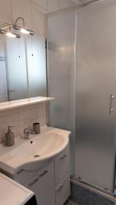 La salle de bains blanche est pourvue d'un lavabo et d'une douche. dans l'établissement Apartman Crikvenica 35862 - Rea, à Crikvenica