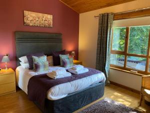1 dormitorio con 1 cama con toallas en Silver Birch Lodge with Hot Tub, en Cupar
