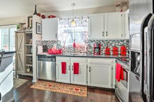 a kitchen with white cabinets and red towels at Colorado Springs House 5 Mi to Downtown in Colorado Springs