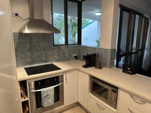 a kitchen with a stove top oven next to a window at Our Beach House in Bribie Island in Bongaree