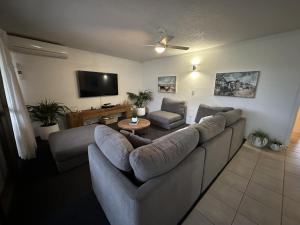 a living room with a couch and a flat screen tv at Our Beach House in Bribie Island in Bongaree