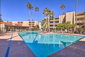 a large swimming pool with palm trees in front of a building at Scottsdale Resort Condo Near Old Town! in Scottsdale