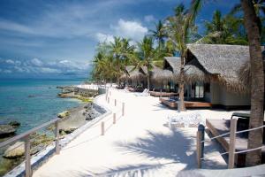 a beach with chairs and umbrellas and the ocean at Maitai Rangiroa in Avatoru