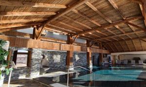 a house with a pool in a room with wooden ceilings at Hotel Etrier in Crans-Montana