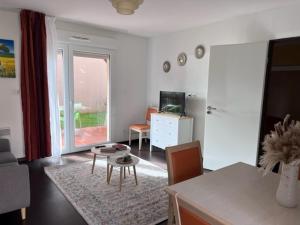 een woonkamer met een tafel en een woonkamer met een bank bij Les bords de l'Aveyron in Nègrepelisse