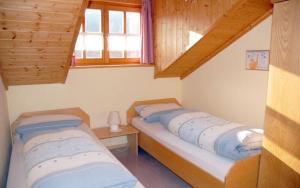 Duas camas num pequeno quarto com tectos em madeira em Ferien- und Freizeithof Bindl em Sankt Englmar
